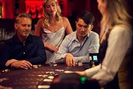Live dealer at a card table managing Andar Bahar with visible card decks and betting layout